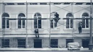 Ouvriers sur un échafaudage rénovant la façade d'un immeuble