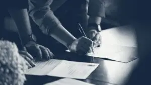 Personne en vêtement de travail orange remplissant un document