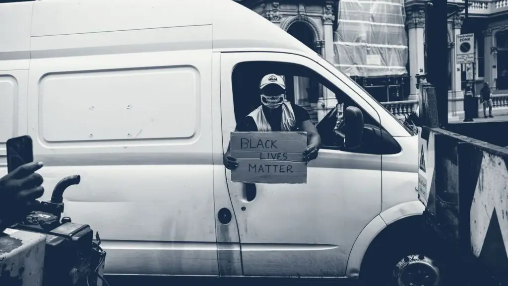 Artisan assis à l'arrière de son fourgon utilitaire blanc