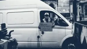 Artisan assis à l'arrière de son fourgon utilitaire blanc