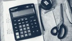 Calculatrice et fournitures de bureau posées sur un plan de travail