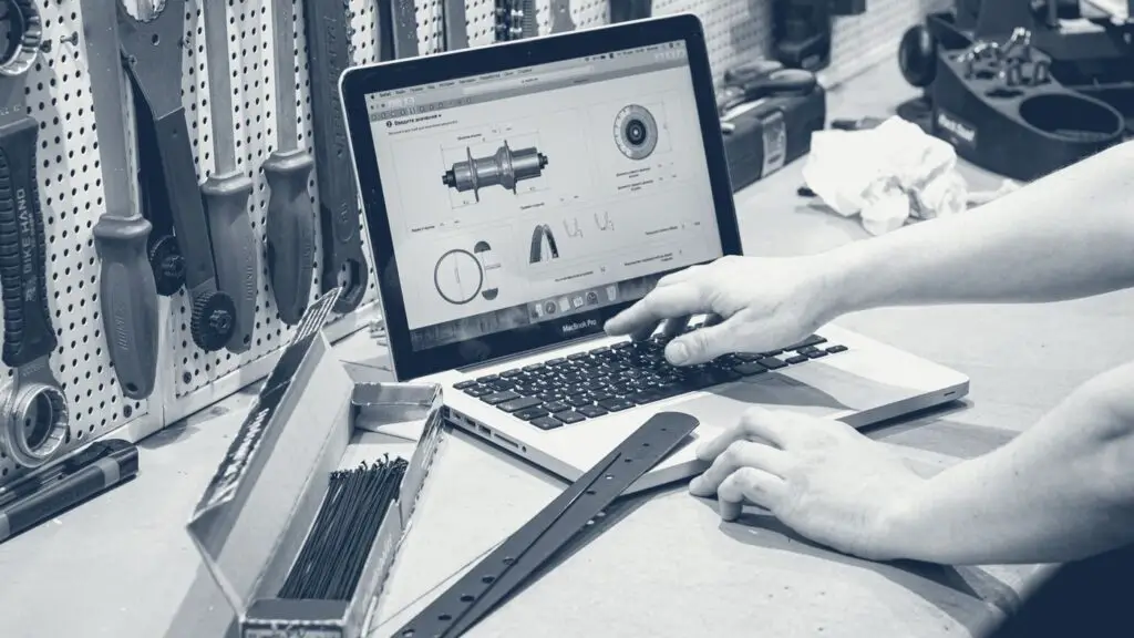 Artisan travaillant sur un ordinateur portable entouré de ses outils